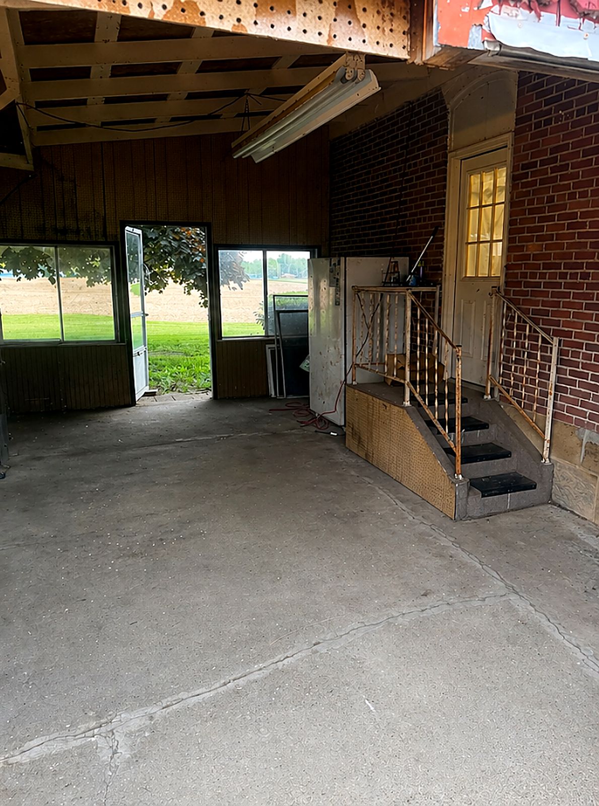 After: covered garage area filled with trash bags, cleared to bare concrete