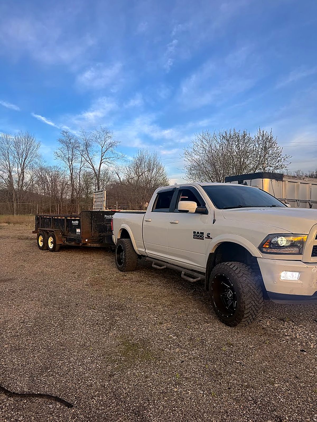 Prestige pickup truck and dump trailer parked on a gravel lot